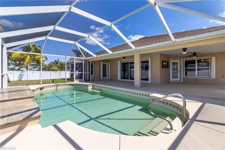 View of swimming pool featuring a patio area, fence, a fenced in pool, and a ceiling fan
