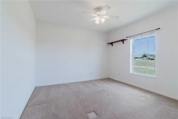 Unfurnished room featuring baseboards, a ceiling fan, and carpet