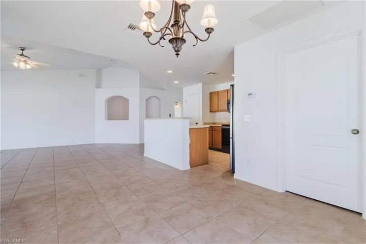 Kitchen featuring visible vents, a center island, open floor plan, light countertops, and vaulted ceiling