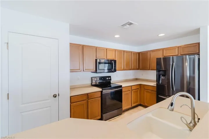 Kitchen with visible vents, recessed lighting, appliances with stainless steel finishes, light countertops, and a sink