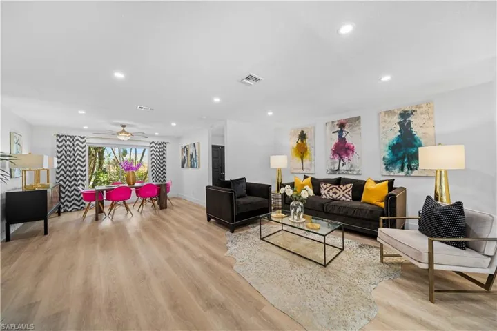 Open-concept living and dining area featuring light wood-finish flooring, recessed lighting, and a ceiling fan
