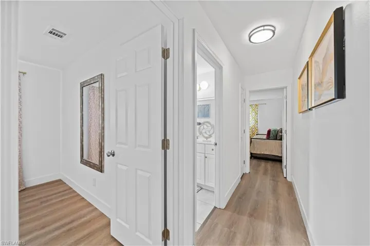 Corridor featuring wood-finish flooring, recessed lighting, and white paneled doors