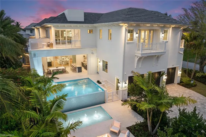Spacious pool with integrated spa and water shelf.