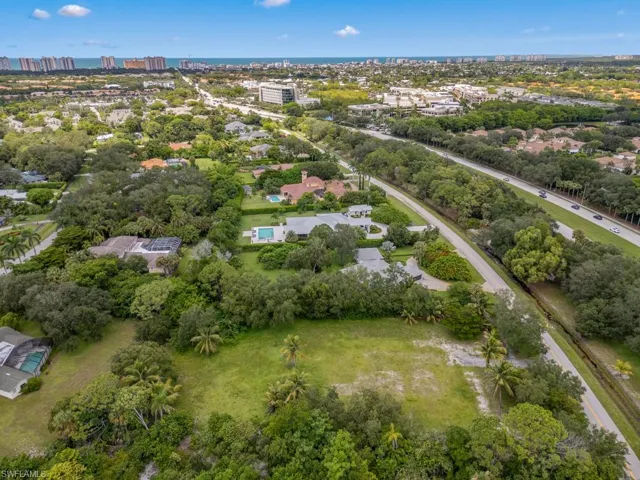 Aerial view of property and surrounding area with a tree filled landscape