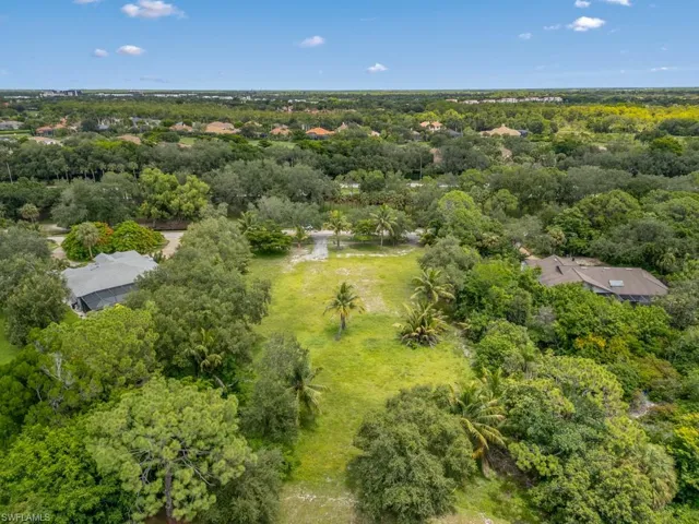 Aerial view of property's location with a heavily wooded area