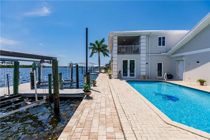 View of swimming pool with a dock and a water view