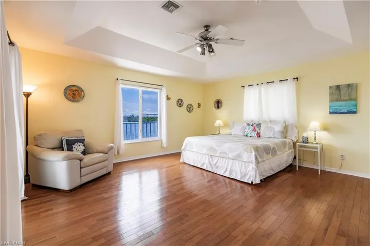 Bedroom featuring a tray ceiling, hardwood / wood-style flooring, and ceiling fan