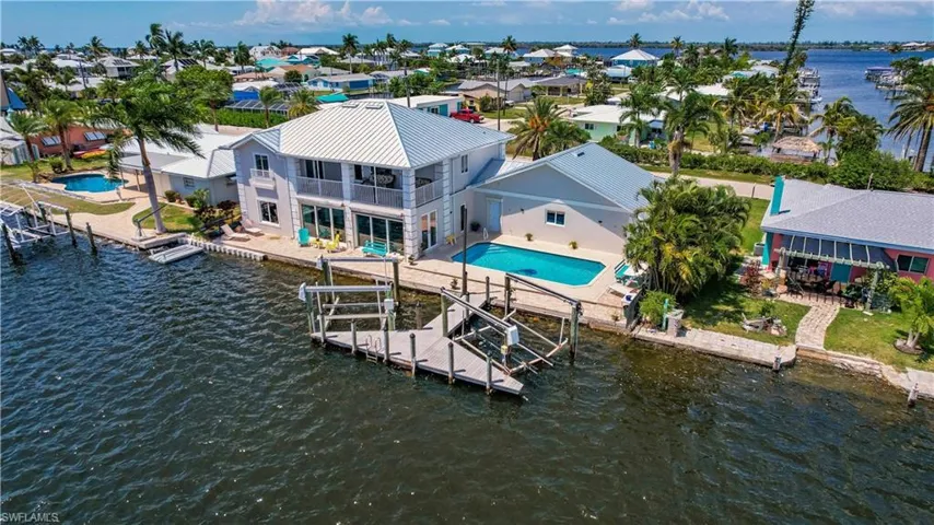 Dock area with a patio, a balcony, and a water view