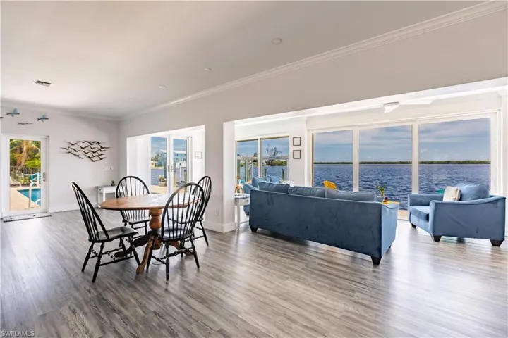 Dining space featuring a water view, dark hardwood / wood-style flooring, and ornamental molding