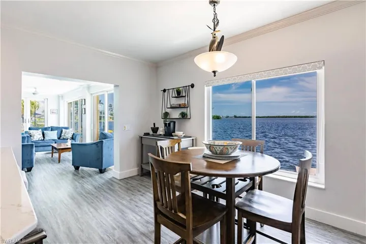 Dining room with crown molding, hardwood / wood-style flooring, and a water view