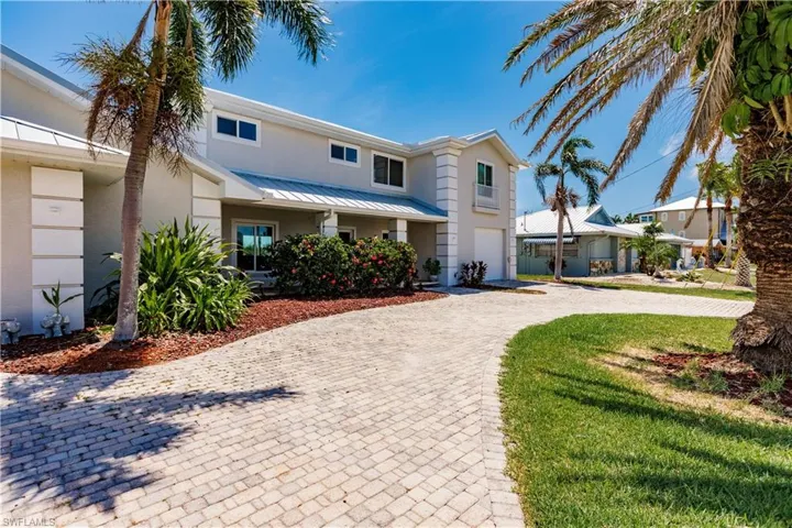 View of front facade featuring a front lawn and a garage