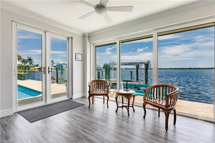Sunroom with a water view and ceiling fan