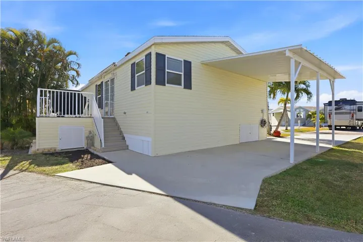 View of side of home featuring a carport and a patio