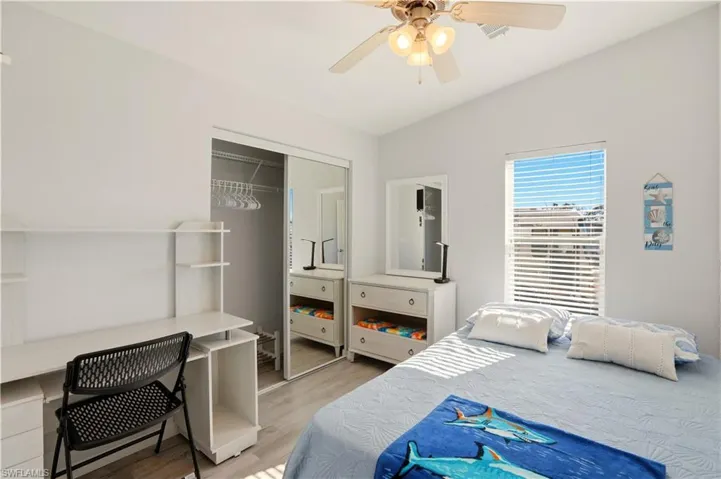 Bedroom with a closet, light wood finished floors, and a ceiling fan