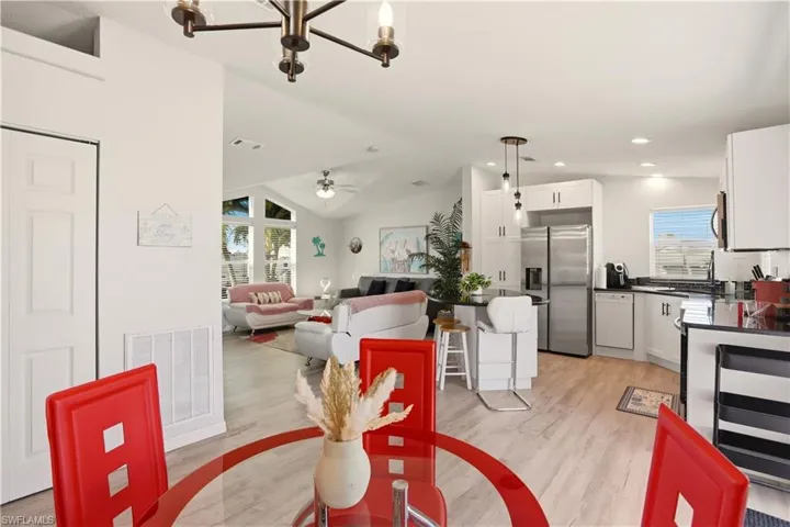 Dining space with a ceiling fan, light wood-type flooring, lofted ceiling, and suspended lighting