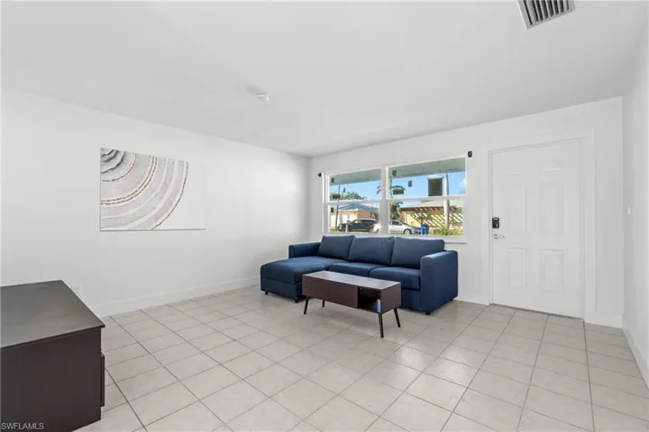 (Virtually Staged) Living area featuring baseboards and light tile patterned floors