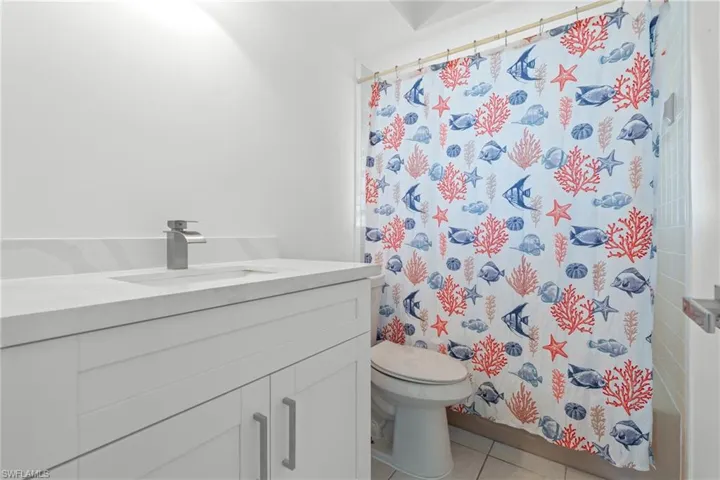 Full bathroom with vanity, light tile patterned floors, and shower / bath combo