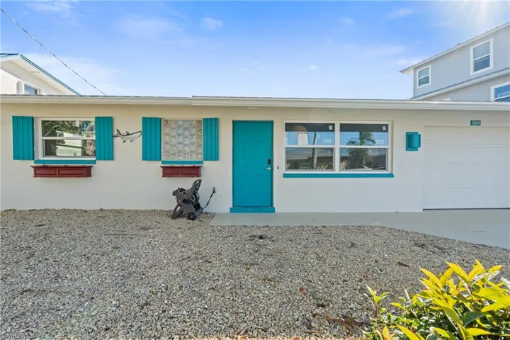 View of front of property with stucco siding, a garage, and driveway