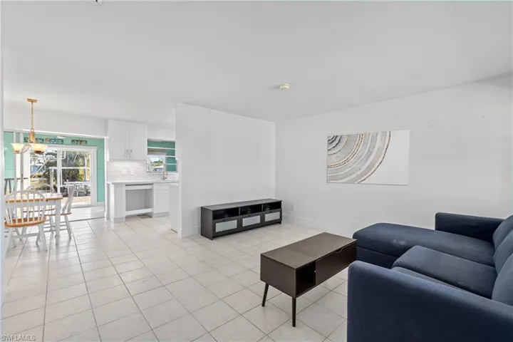 (Virtually Staged) Living area with light tile patterned floors and baseboards
