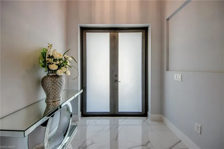Foyer entrance featuring baseboards and marble finish floor