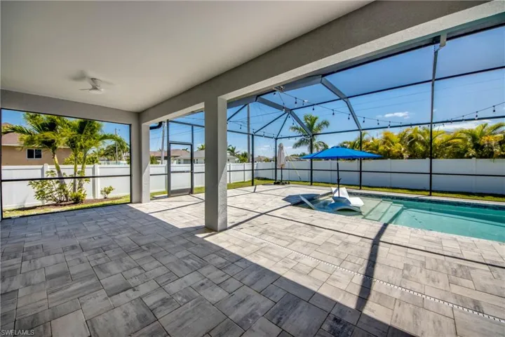 View of pool featuring a lanai, a fenced backyard, a ceiling fan, and a patio area