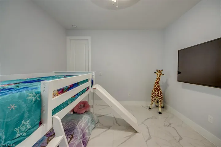 Bedroom featuring baseboards and marble finish floor