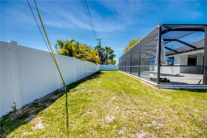 View of yard with glass enclosure, a fenced backyard, and a fenced in pool