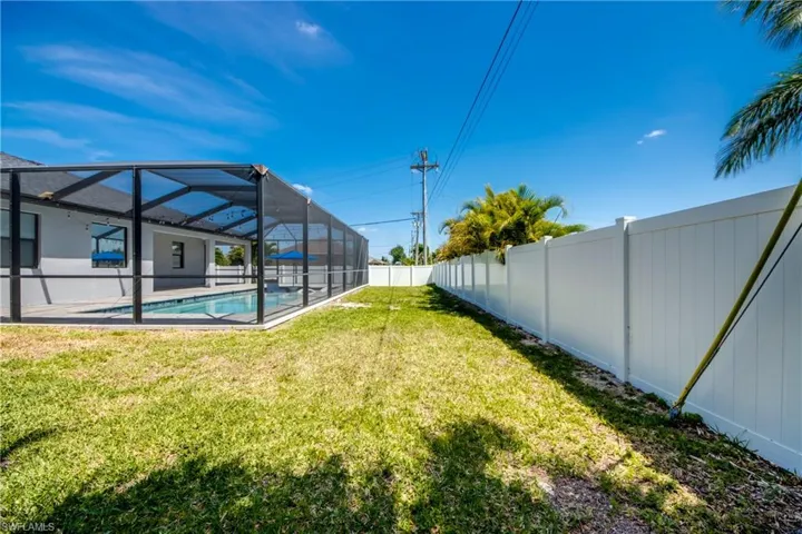 View of yard with glass enclosure, a fenced backyard, and an outdoor pool