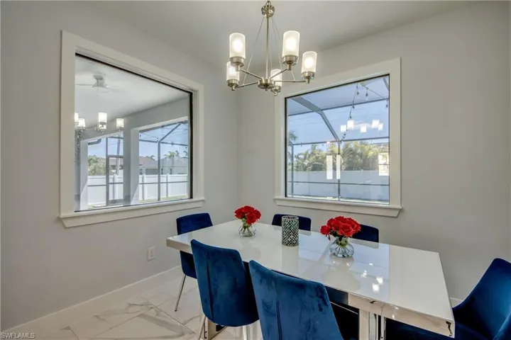 Dining area featuring baseboards, a notable chandelier, and marble finish floor
