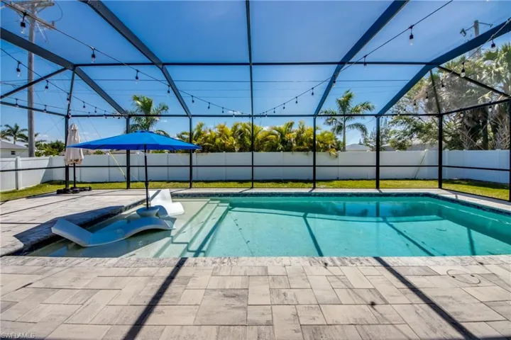 View of swimming pool with a fenced in pool, a fenced backyard, and a lanai