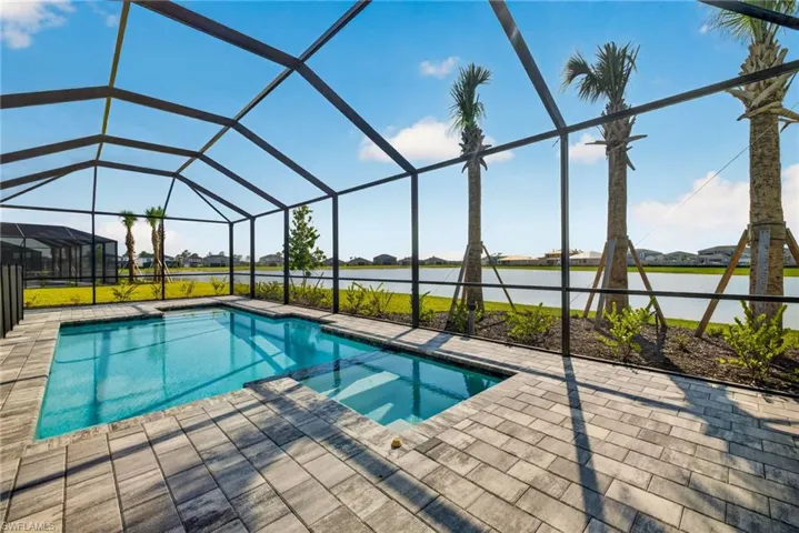 The property features a screened-in swimming pool area with a paver patio, offering clear views of the lake and surrounding landscape