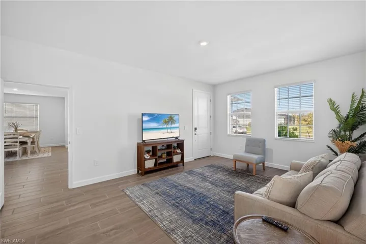 Spacious living area featuring light-toned flooring and ample natural light from the two windows