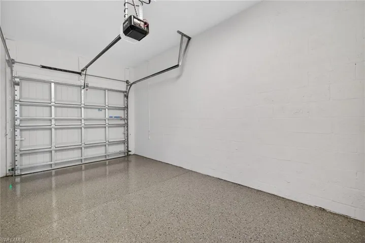 The garage features a concrete floor with a speckled finish and white painted block walls