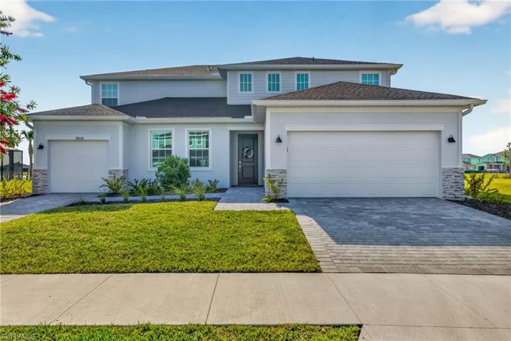 The property features a two-story design with a light gray exterior, a dark gray roof, and stone facade accents