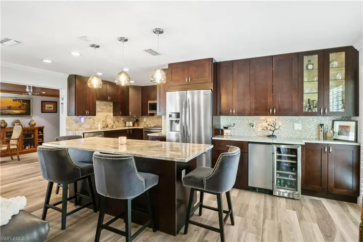 Chef-inspired kitchen featuring a built-in wine cooler and oversized breakfast bar for entertaining.