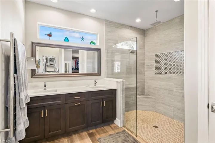 Resort-style primary bathroom with large walk-in shower and double vanity.
