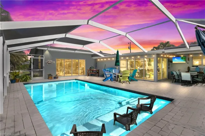 Gorgeous backyard oasis featuring the pool and a colorful sunset horizon.