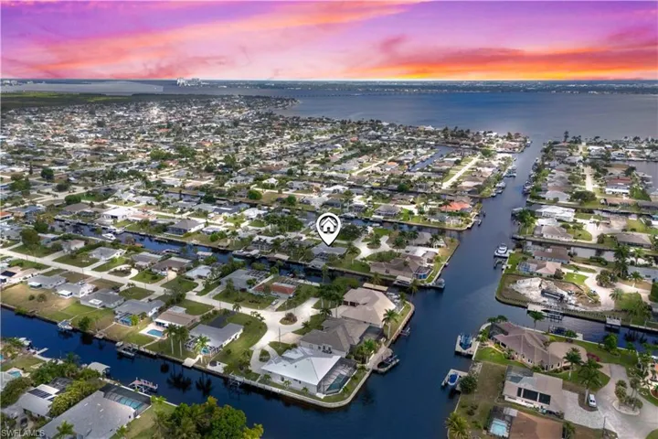 Stunning aerial perspective showcasing waterfront access and vibrant sunset skies.