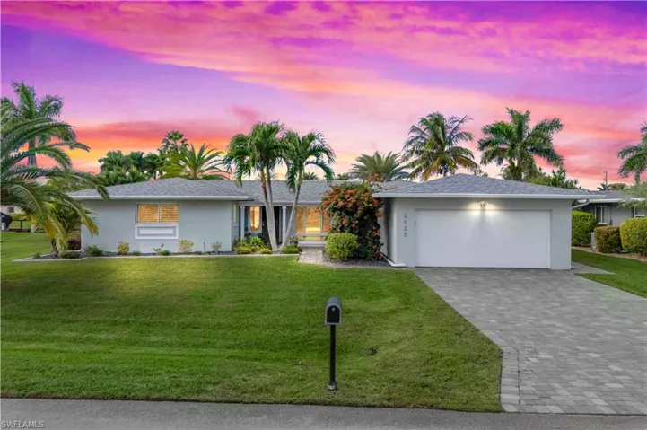 Dramatic sunset over the backyard as seen from the beautifully landscaped front of the home.