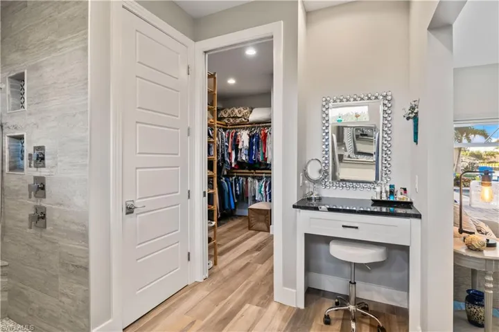 Resort-style bathroom retreat with elegant finishes. with a separate makeup vanity for convenience.