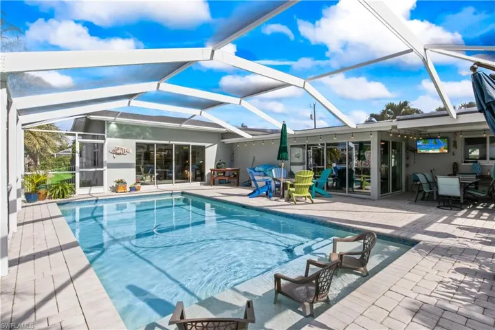 Private outdoor retreat with pool, sun shelf, and tranquil water views.