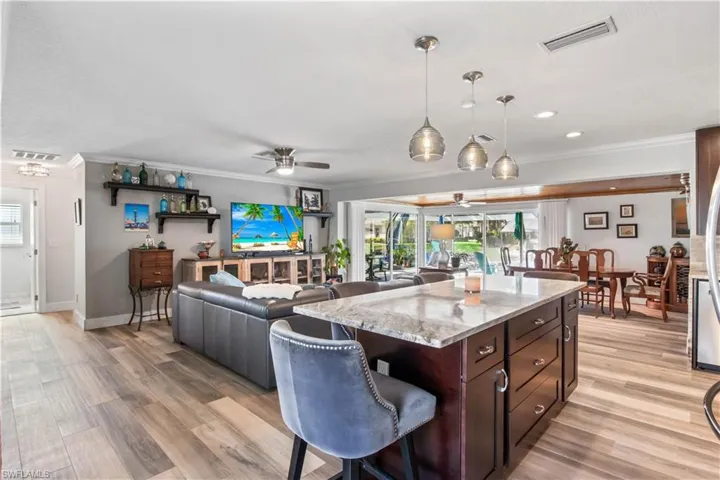Living and kitchen areas designed for seamless indoor-outdoor flow to the lanai and pool.