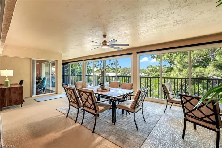 Sunroom / solarium with a textured wall and carpet flooring