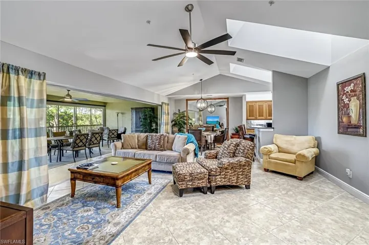 Living room featuring a ceiling fan, suspended lighting, and light tile patterned floors