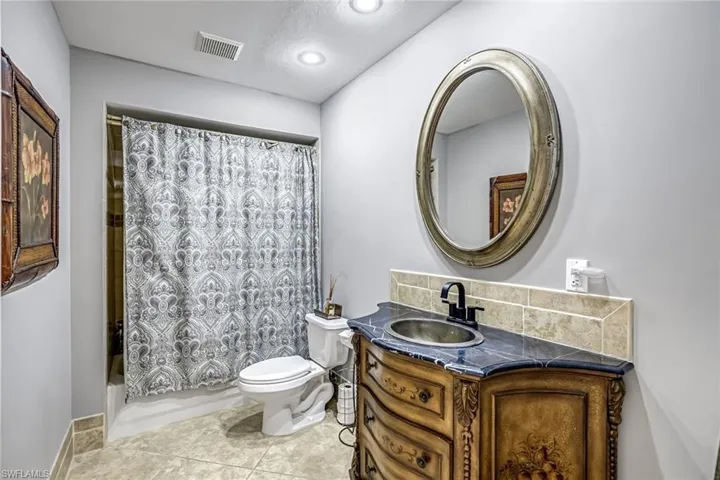 Full bath with vanity, light tile patterned flooring, and shower / bath combination with curtain