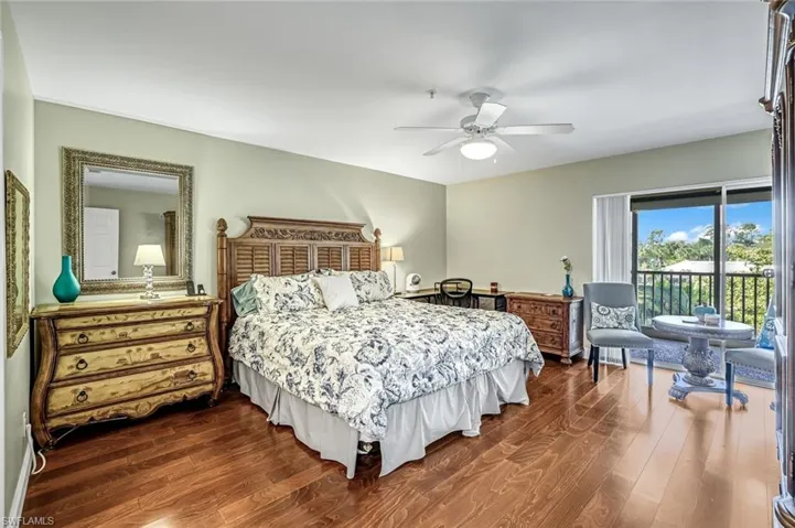 Bedroom with dark wood-style flooring, access to outside, and a ceiling fan