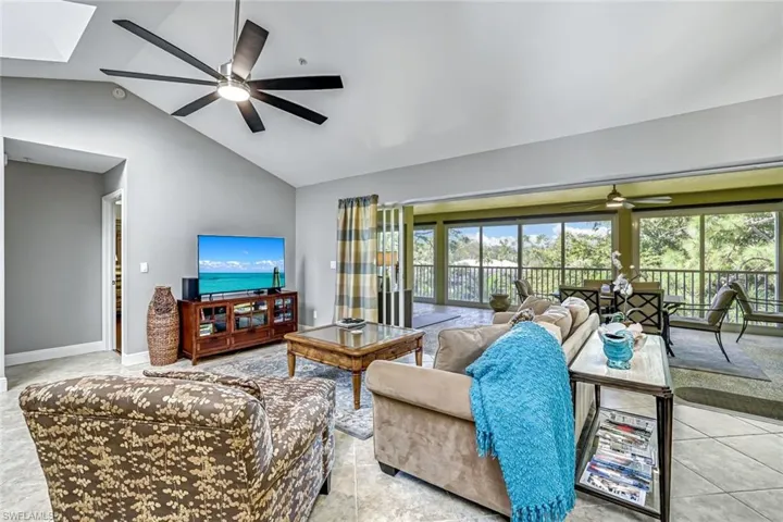 Living room featuring ceiling fan and vaulted ceiling