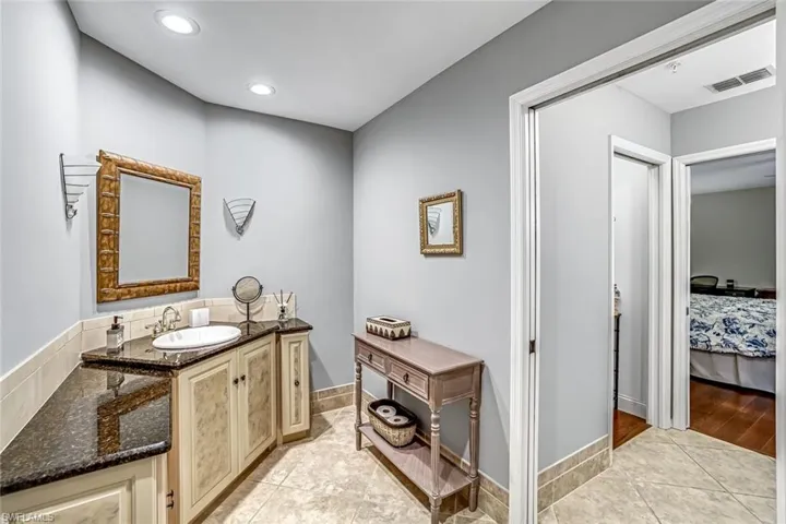 Bathroom featuring light tile patterned floors, vanity, ensuite bathroom, and recessed lighting