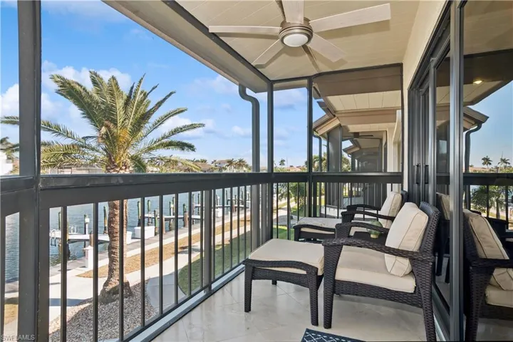 Balcony featuring a water view and ceiling fan