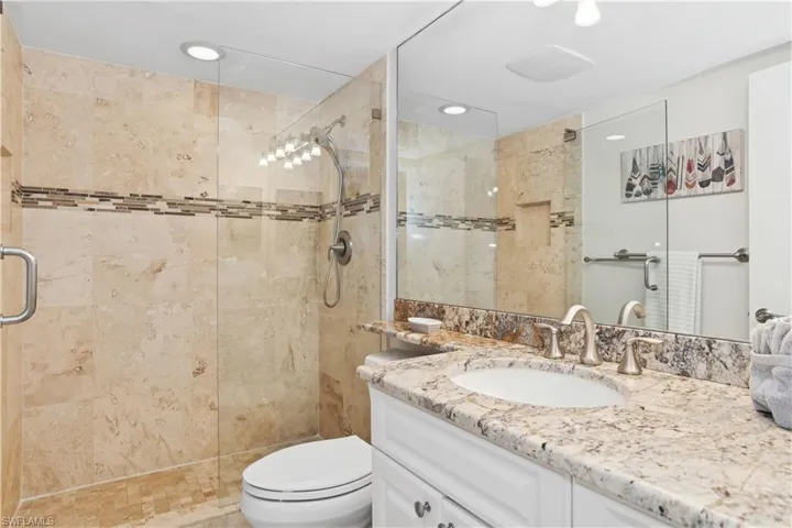Bathroom featuring vanity, toilet, and an enclosed shower